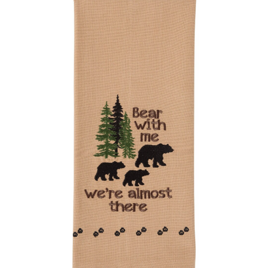 Beige towel with embroidered bears and trees design on a white background