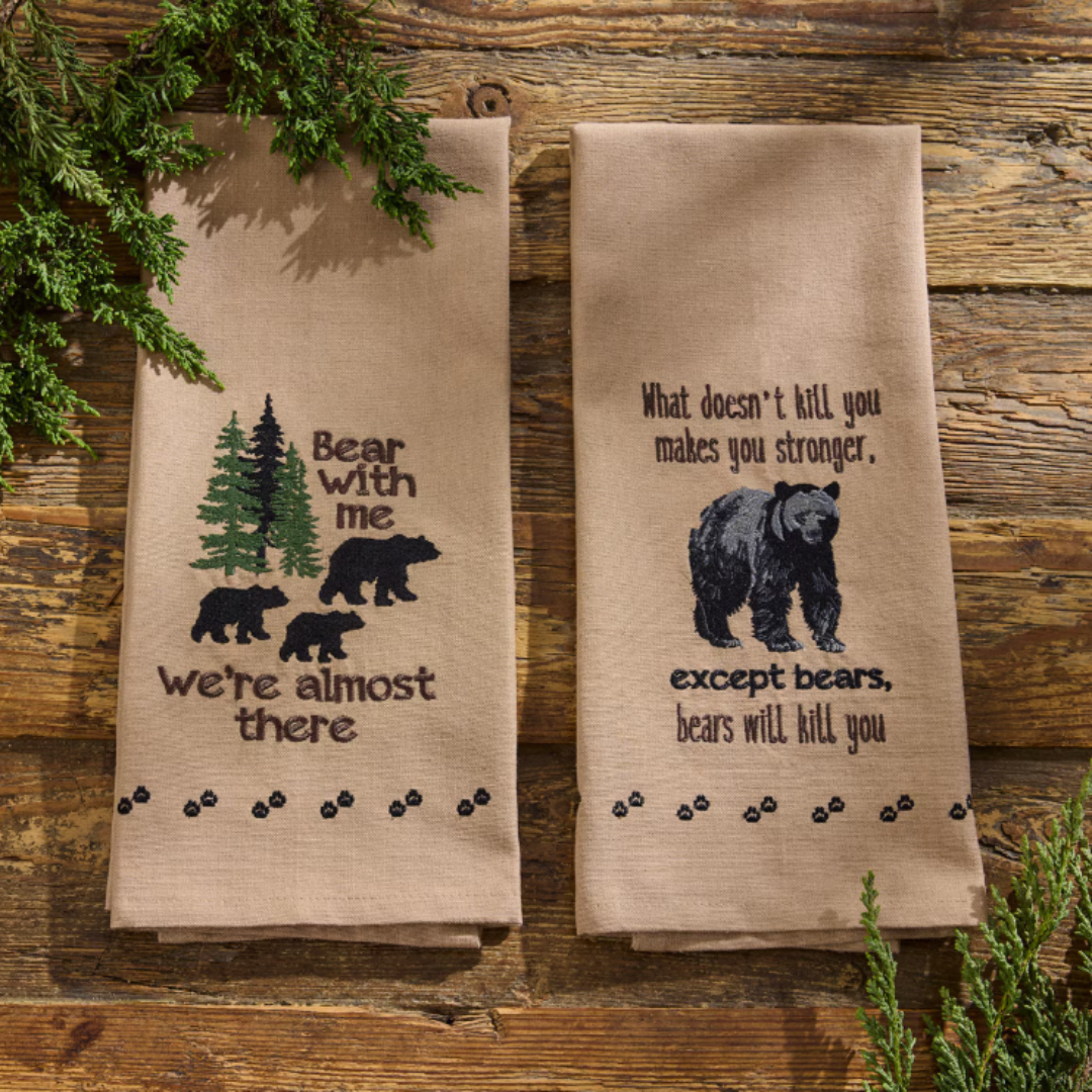 Woodland tea towels with bear-themed designs on a wooden background