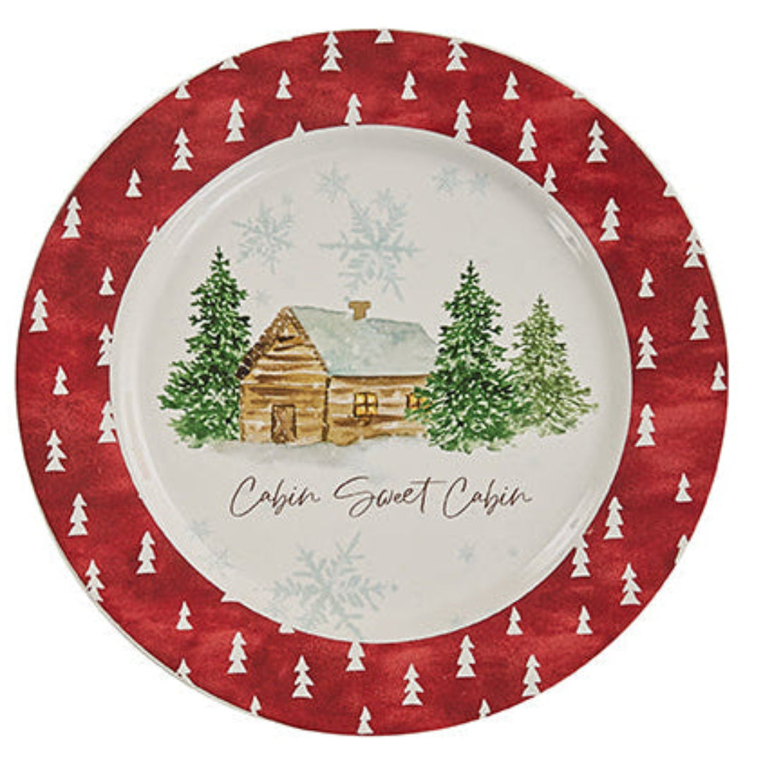 Decorative Christmas plate with a cabin and tree design on a red background