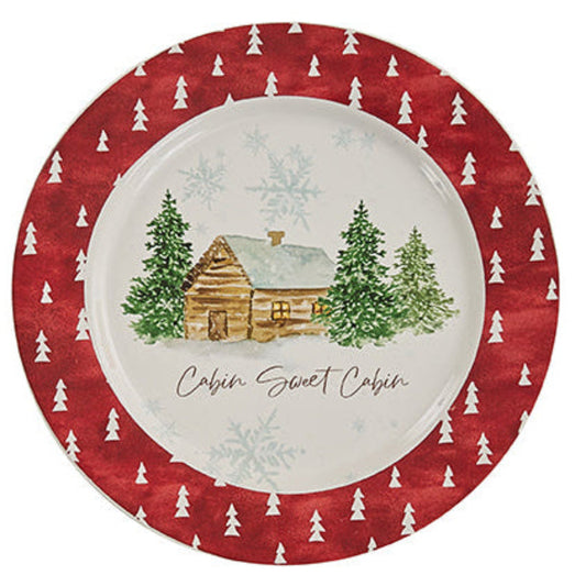 Decorative Christmas plate with a cabin and tree design on a red background