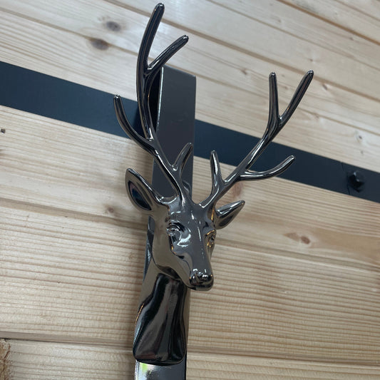 Metallic deer head wall hook on a wooden surface
