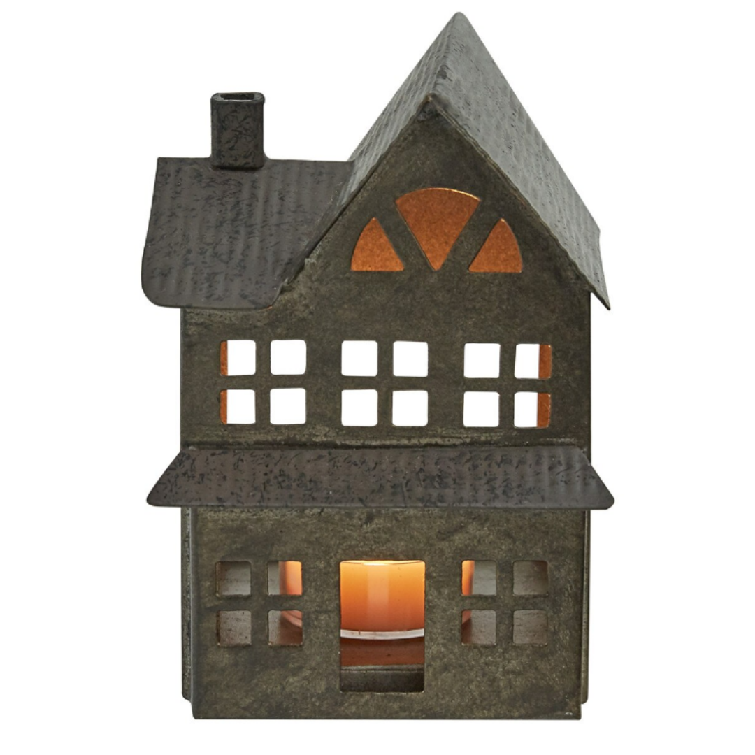 Decorative house-shaped lantern with a lit candle inside on a white background. Christmas Decor