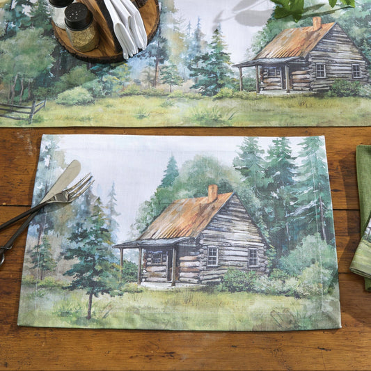 Table setting with placemats, napkins, and cutlery featuring a cabin in the woods design on a wooden table.