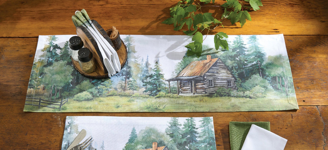 Table setting with placemats, napkins, and cutlery featuring a cabin in the woods design on a wooden table.