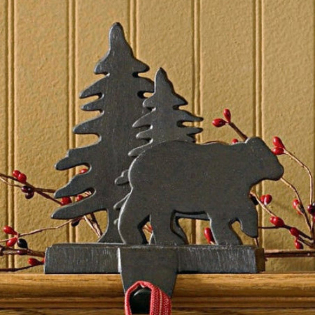 Christmas stockings hanging on a mantel with decorative metal animals above.