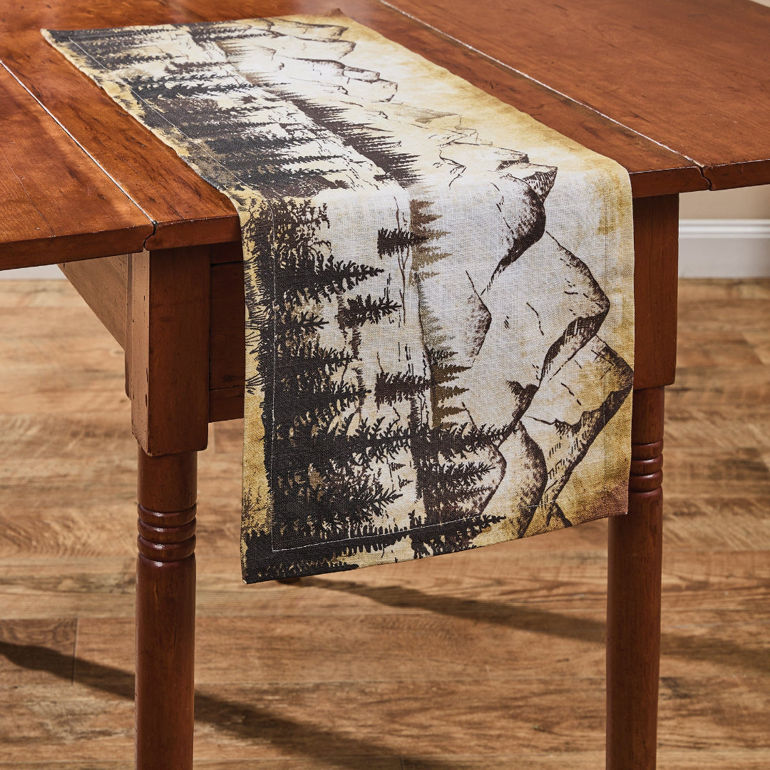 Nature-themed table runner featuring trees and mountains.