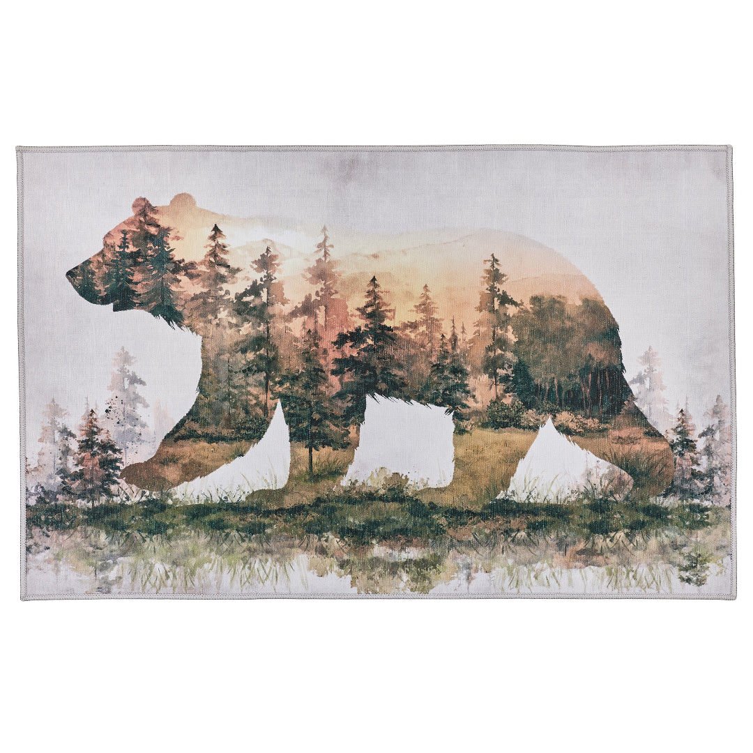 A rectangular area rug featuring a watercolor-style double exposure design of a bear silhouette filled with a forest landscape, shown against a plain white background.