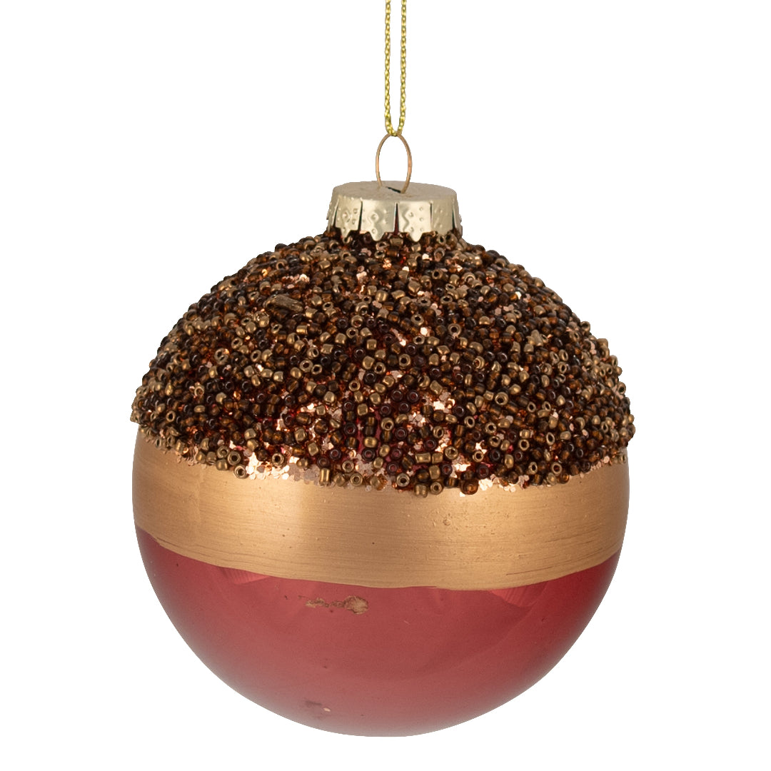 Decorative Christmas ornament with gold and red glitter on a tree