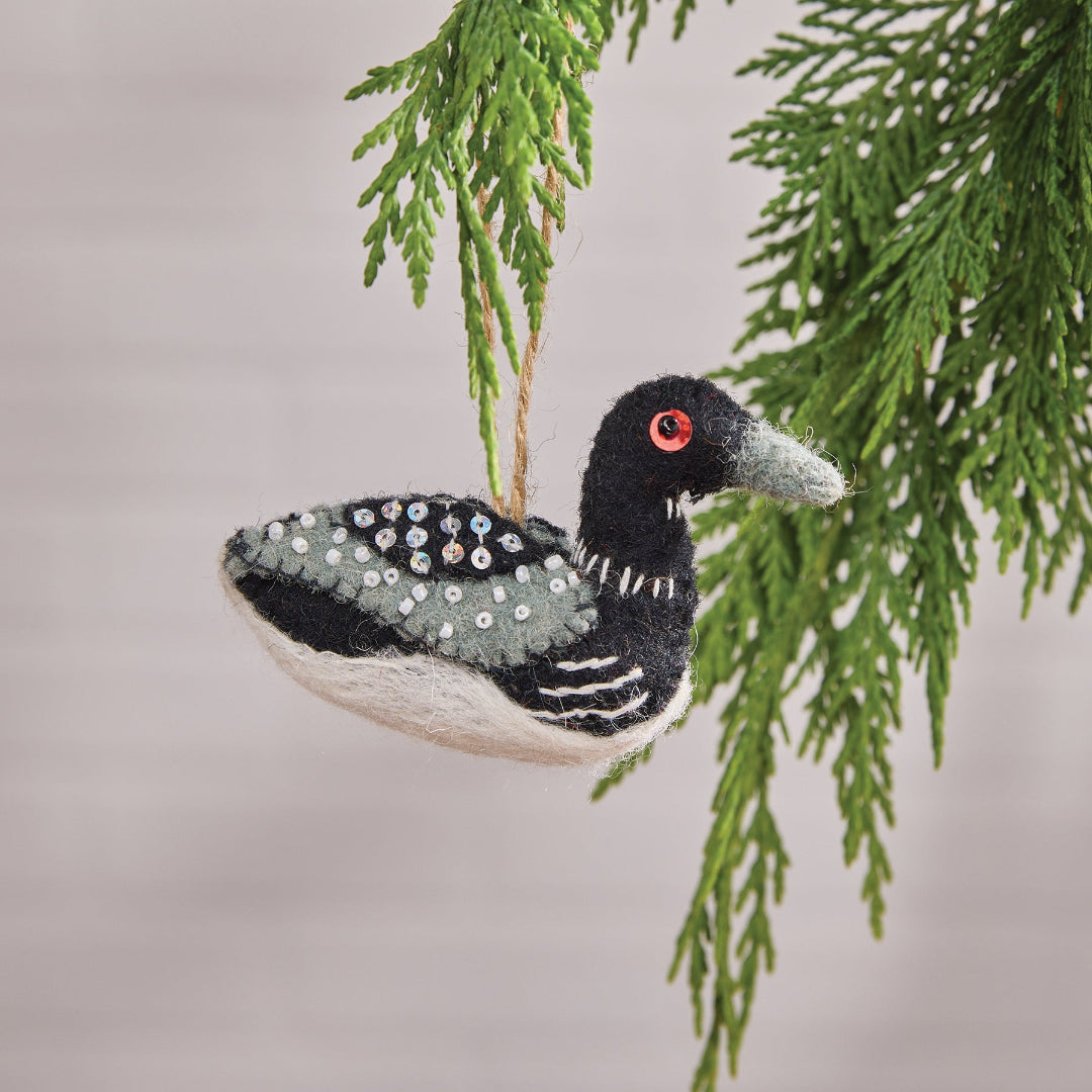 Decorative Loon ornament with sequins hanging on a branch