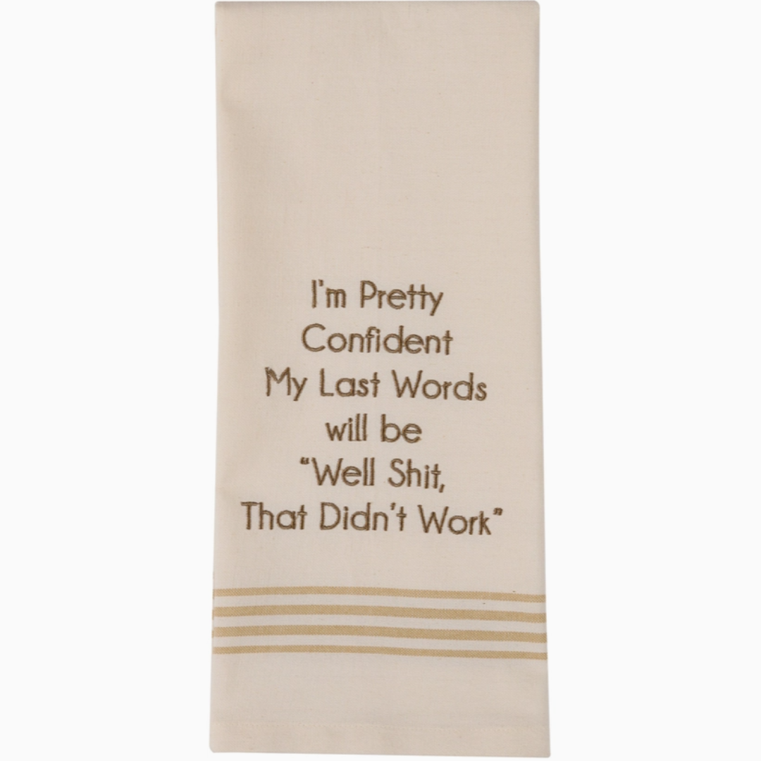 Beige towel with brown humorous text and decorative lines on a white background