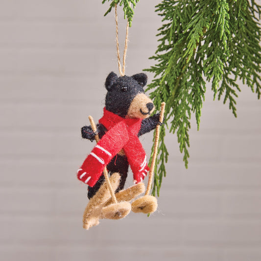 Bear Felt ornament with a red scarf and skis hanging from a branch.