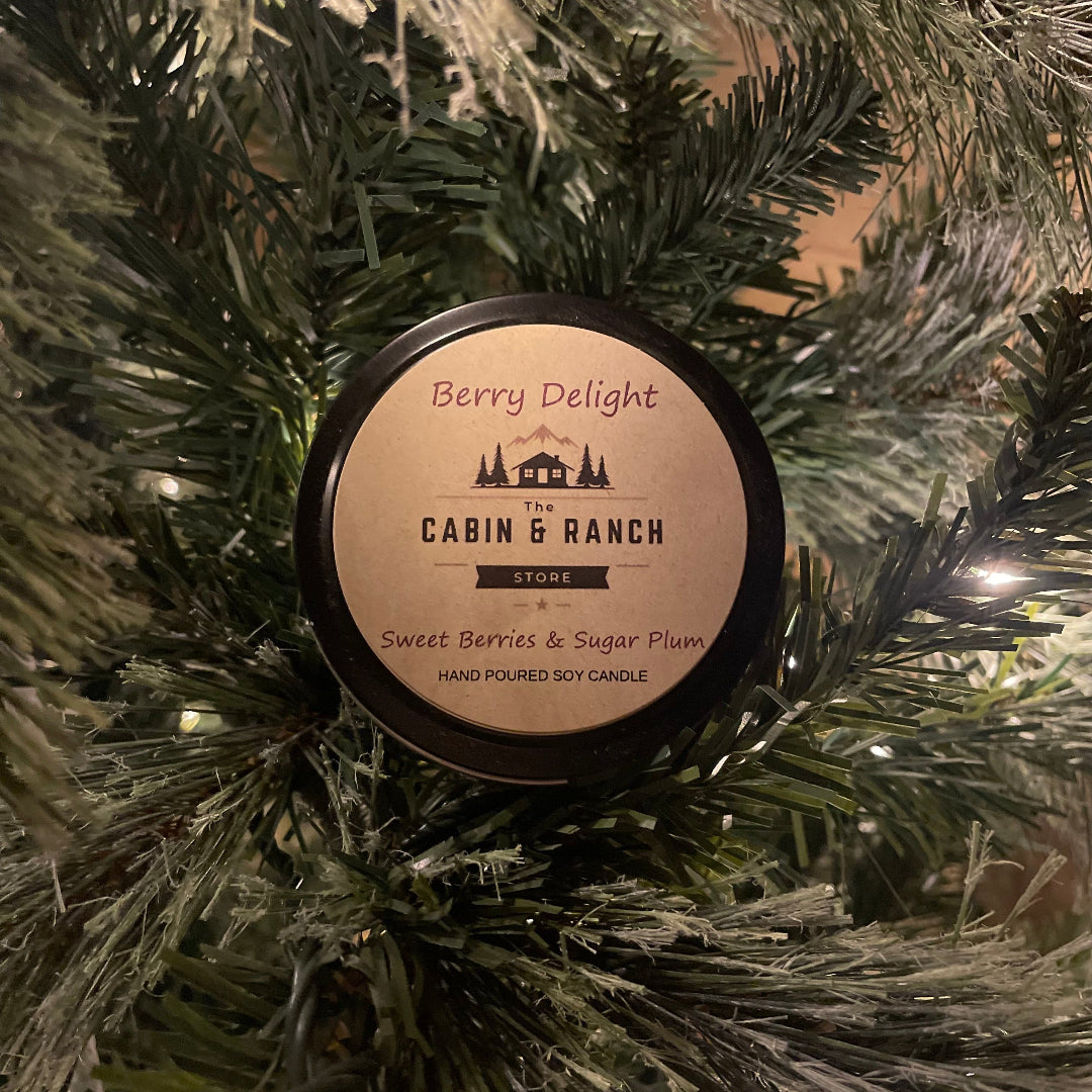 Candle labeled Berry Delight from The Cabin & Ranch Store on a Christmas tree.