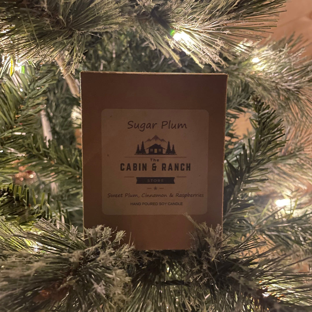 The Sugar Plum Candle Gift Boxed from The Cabin & Ranch Store on a Christmas tree.