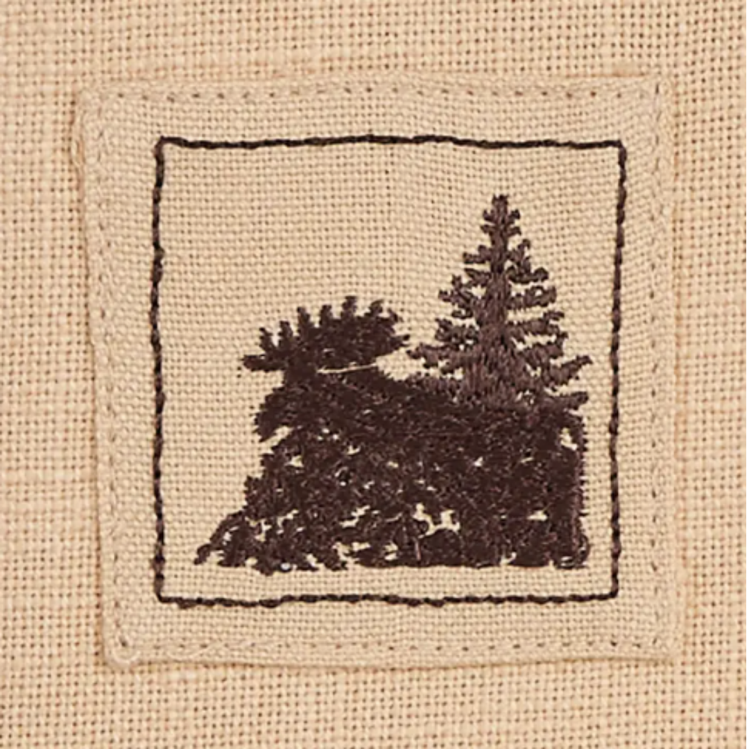 Cross-stitched design of a moose and trees on fabric napkin