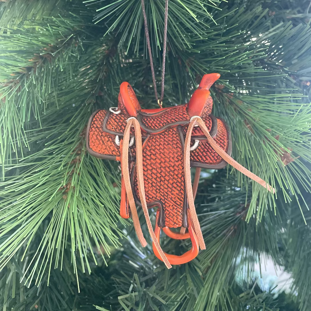 Decorative horse saddle ornament hanging on a Christmas tree.